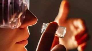 Die Doktorandin Frieda Nagler riecht an einer Duftstoffverkapselung, deren Geruch über die Nase wahrgenommen werden kann. (Bild: Jens Meyer (Universität Jena))