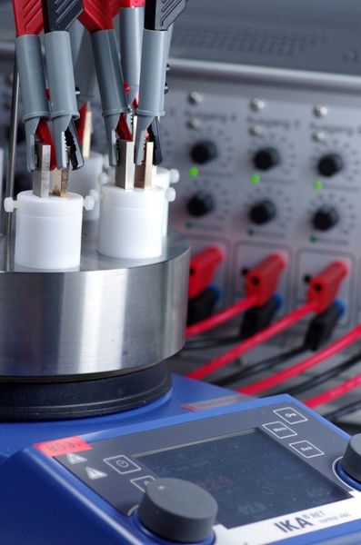 Bis zu acht verschiedene Versuche können gleichzeitig in diesem Screening-Elektrolyseur durchgeführt werden. In jedem der kleinen Kunststoffbecher stecken zwei Elektroden.   (JGU Mainz; Carsten Siering)