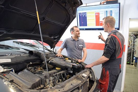 Voller Überblick: Erdal Acar (li.) bespricht mit seinem Mitarbeiter Timo Elias den Stand der Auftragsbearbeitung direkt am Monitor in der Werkstatt. (Bild:  Rubbel/»kfz-betrieb«)
