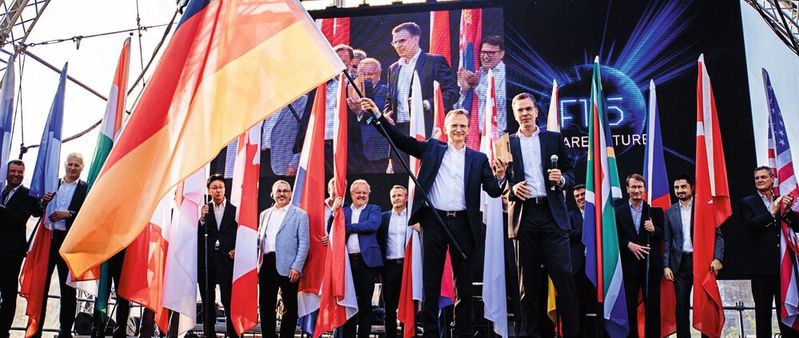 Die Flender-Geschäftsführer Andreas Evertz (links) und Christian Terlinde eröffnen die Jubiläumsfeierlichkeiten. Im Hintergrund die Leiter der Flender-Auslandsstandorte, die den Spirit mit zu den Feiern in ihren Ländern nehmen.(Bild:  Flender)