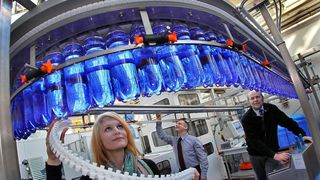 Entwickelt wurde die neue Anlage für den Transport leerer Flaschen – doch auch mit vollen läuft sie einwandfrei, wie Studentin Philine Bernau und die beiden wissenschaftlichen Mitarbeiter Frank Hladik und Uwe Böttger (v.l.) bei Probeläufen am Versuchstand an der TU Chemnitz zeigen.  (Bild: TU Chemnitz/Uwe Meinhold)