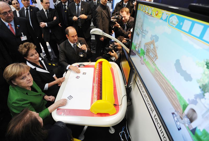 Angela Merkel und Dilma Rousseff, Präsidentin der Föderativen Republik Brasilien, testen den Lerncomputer. (Archiv: Vogel Business Media)
