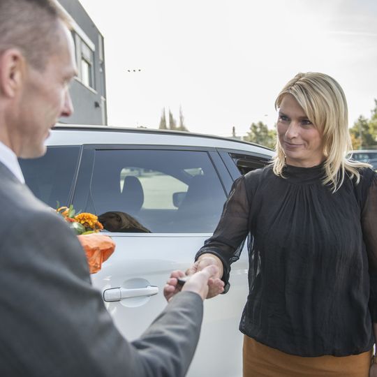 Symbolbild für den Autoverkauf: Ein Mitarbeiter übergibt die Wagenschlüssel an eine Käuferin.(Bild:  Pro Motor)