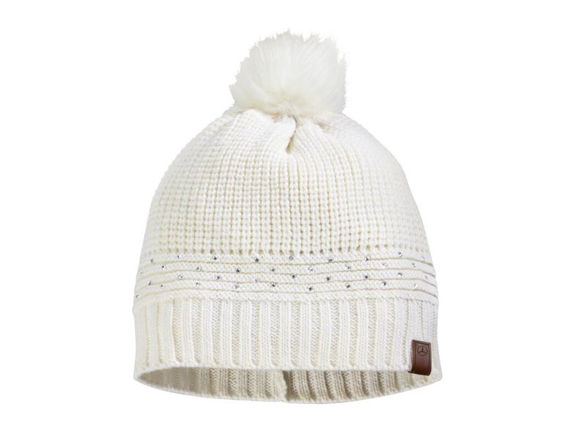 Wollweiße Damen-Strickmütze mit Fellbommel aus 60 % Acryl und 40 % Wolle, mit Glitzersteinchen und Lederbadge mit geprägtem Sternlogo. Artikelnummer: B66952246. (Bild: Daimler)