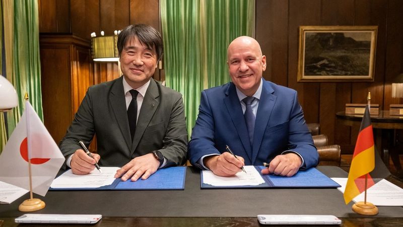 Yoshimoto Matsuda, Kawasaki Heavy Industries, und Steffen Haack, Bosch Rexroth (v. l.) unterzeichnen am 22. September 2026 in Stuttgart die Vereinbarung. (Bild:  Bosch Rexroth)