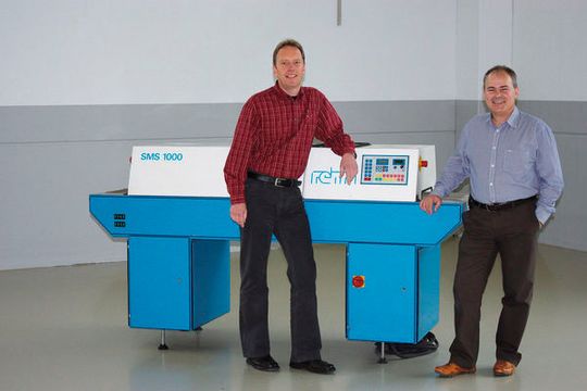 Wolfgang Zeifang (links), erster Mitarbeiter und heute technischer Betriebsleiter von Rehm, und Geschäftsführer Johannes Rehm vor der ersten Lötanlage von 1990.(Bild:  Rehm Thermal Systems)