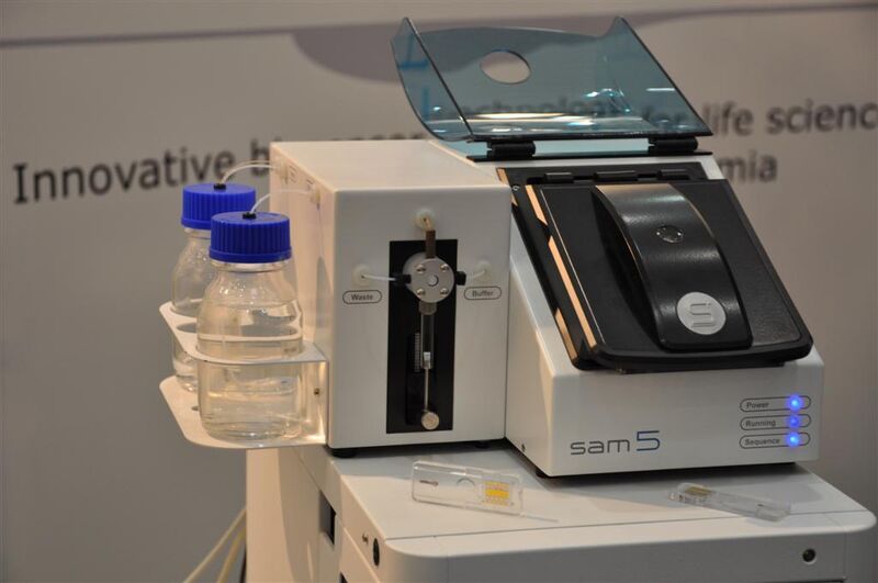 Das Biosensorsystem SAM5 von Saw Instruments detektiert biomolekulare Wechselwirkungen und deren Kinetik in Echtzeit. Als zentrale Detektionseinheit ermöglicht der Sensorchip die parallele Durchführung von bis zu fünf unterschiedlichen Bindungsexperimenten. (Archiv: Vogel Business Media)