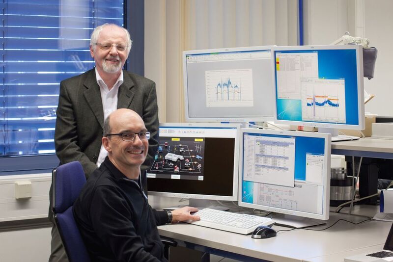 Dr.-Ing. Richard Öchsner (hinten) und Systemadministrator Heinz Schmid vom Fraunhofer IISB am Hauptarbeitsplatz des Energiemonitoringsystems. (Bild: Siemens)