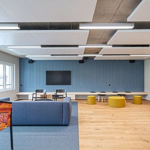 Der Aufenthaltsbereich bietet Raum für gemeinsames Zusammenkommen und Erholung. Mitarbeitende finden hier einen Ort, um neue Energie zu tanken, sportliche Ereignisse mitzuverfolgen oder den Tag bei einem Feierabendbier ausklingen zu lassen. Mit einem Schmunzeln fällt der Flipperkasten mit dem Schriftzug der Metal-Band «Iron Maiden» ins Auge.(Bild:  NOWW AG)