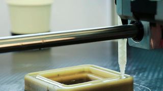 Beim additiven Freiformgießen wird die Hülle des Bauteils im FDM-Druck aufgebaut. Anschließend befüllt eine Dosiereinheit im Drucker die Form mit einem Duroplast. (Fraunhofer IPA, Rainer Bez)