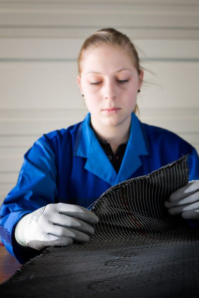 Eine BMW-Mitarbeiterin prüft die Qualität von Carbonfasergewebe. (Bild: BMW)