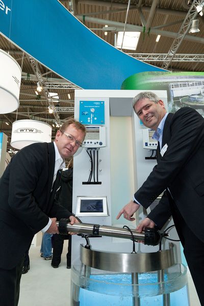 Ulrich Schwab (l.) und Sean Donnelly (r.), Vice President des Bereichs Analytics von Xylem, mit dem neuesten WTW-Online-Sensor auf der Ifat 2012. (Bild: WTW)