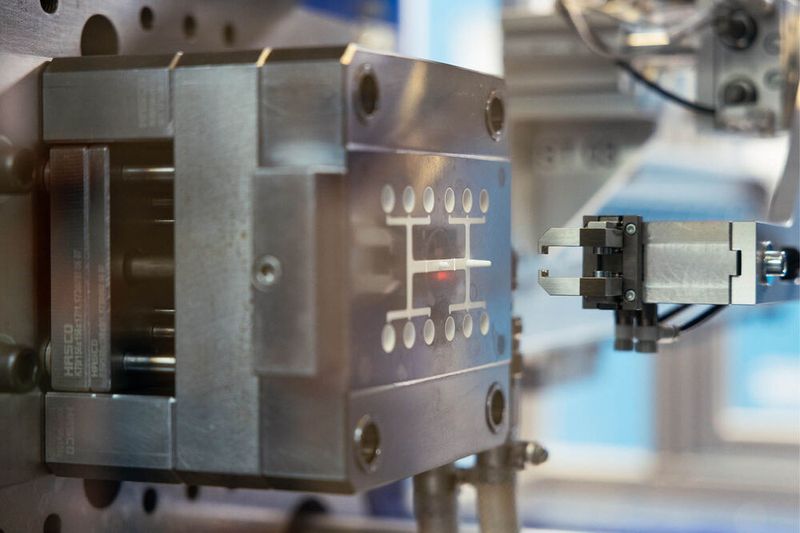 Kunststoffspritzguss mit automatisierter Entnahme: Der Greifer übernimmt die Teile direkt aus dem Werkzeug. (Bild: Vogt AG Verbindungstechnik)