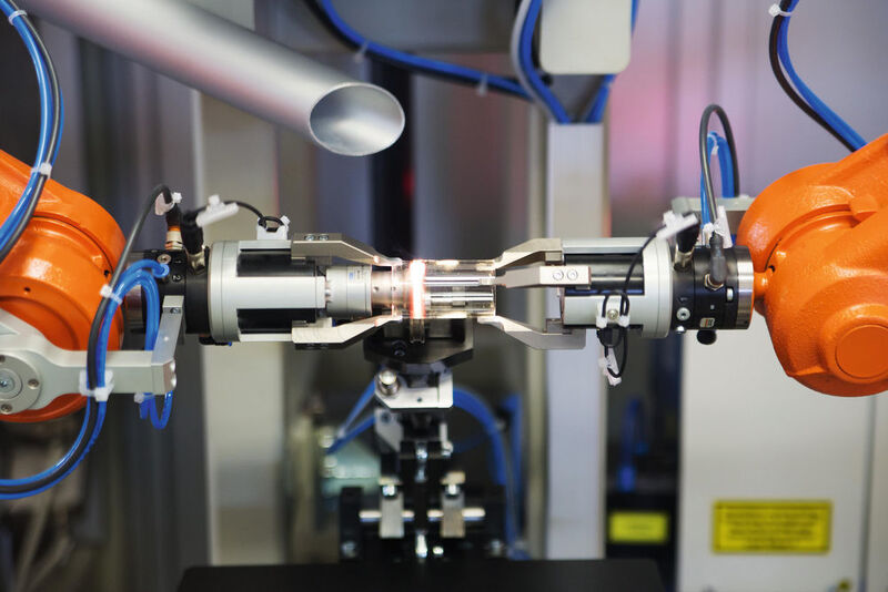 Robu arbeitet mit der ersten robotergestützten Laseranlage, die rotierende Glasbauteile im heißen, viskosen Zustand durch kooperierende Roboter bearbeiten kann. (ABB)