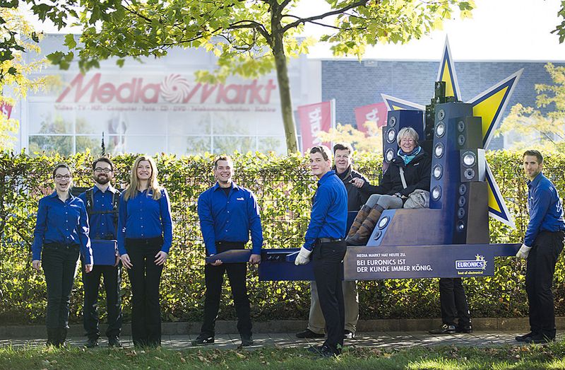 In einer Guerilla-Aktion trugen Mitarbeiter des Euronics Marktes Gütersloh Kunden, die vor dem geschlossenen Media Markt standen, in der Technik-Sänfte zu ihrem Geschäft. (Bild: Euronics)