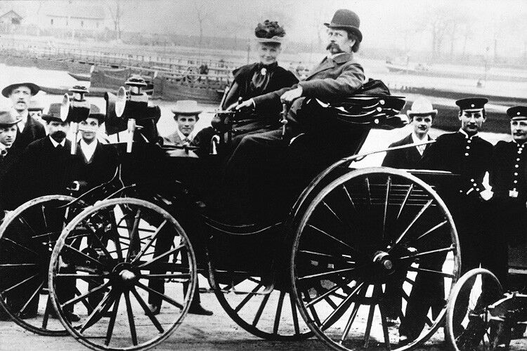 Im Jahr 1893 folgt ein vierrädriges Fahrzeug: Der Benz Victoria verfügt über die auf Carl Benz patentierte Achsschenkellenkung. Der Motor leistet 3 PS (2,2 kW) und das Modell ist in unterschiedlichen Karosserien erhältlich und wird in größerer Stückzahl gebaut. Im Bild Carl Benz mit seiner Frau Bertha Benz. (Daimler)