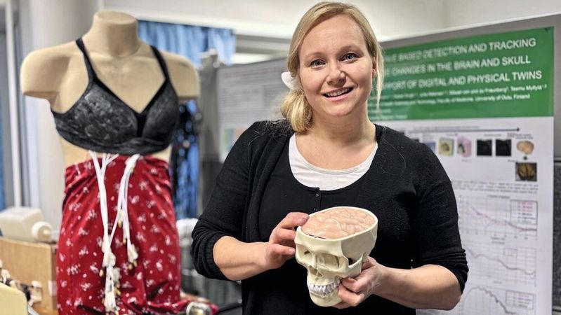 Mariella Särestöniemi ist die leitende Forscherin im Human Body Twin Laboratory. Ihr Team entwickelt und evaluiert Technologien für tragbare und am Körper getragene medizinische Monitoring-Geräte. Sie hält ein Kopfphantom in der Hand, das zur Untersuchung der Signalausbreitung im Hirngewebe verwendet wird. Im Hintergrund ist eine tragbare Weste zur Brustkrebserkennung zu sehen.(Bild:  University of Oulu)