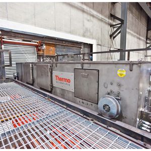 Thermo-Scientific- Sipro-Sondenbügel an einer Warmbreitband-Straße. Zu sehen ist der obere Bügelarm, in dem sich die beiden Röntgenquellen befinden. Das Detektor-Array befindet sich im unteren Bügelarm.