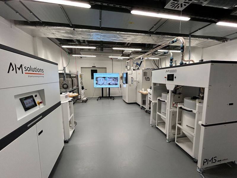 Gemeinsam im Praxistest! Die F1 und das PMS von AM Solutions sind am EOS-Standort in Krailling installiert und werden dort bereits erfolgreich mit einem EOS-SLS-System verwendet. EOS könne nur Gutes über diese Art der Automatisierung bei der additiven Fertigung berichten. (Bild: Rösler Oberflächentechnik)
