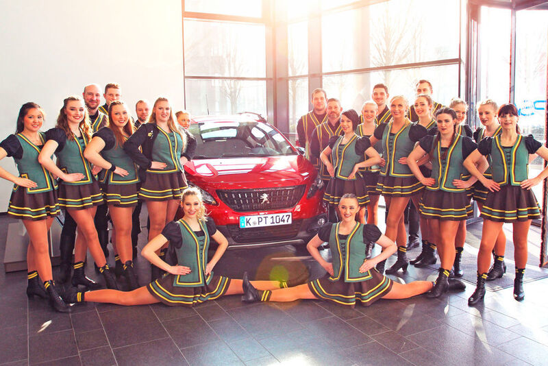 Starke Unterstützung: Die Tanzgruppe „Urbacher Räuber“ mit dem Peugeot 2008. (PSA Gruppe)