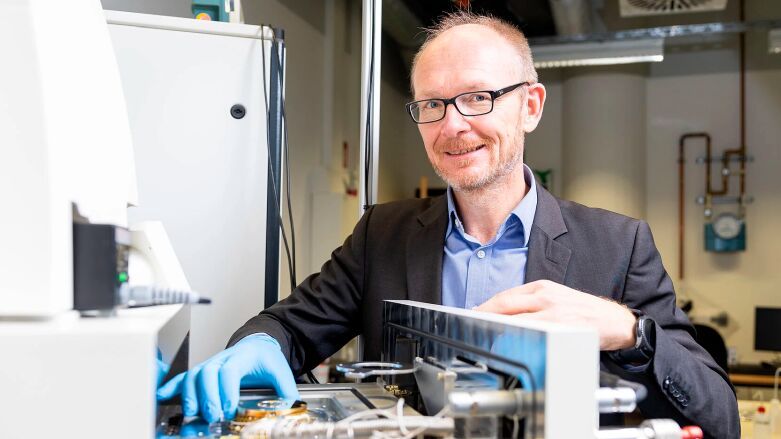Stephan Reitzenstein vor der Probenkammer der Elektronenstrahl-Lithographie-Anlage: Diese Anlage stellt die hochpräzise Nanostrukturen für skalierbare Quantenlichtquellen her.(Bild:  Felix Noak)