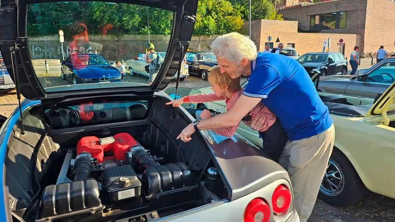 Technik für die Kleinsten erklärt: Armin van Dijk erklärt dem 6-jährigen Georg Wulf, wie der Ferrari-Motor funktioniert. (Bild: OCC)