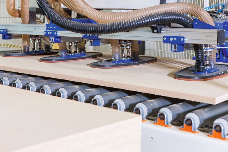 Die Saugspinne nimmt die Dämmplatte zuverlässig und ohne Beschädigungen vom Stapel (im Vordergrund) ab. Über eine weitere Rollenbahn gelangt die Platte zum nächsten Bearbeitungsschritt. (Schmalz)