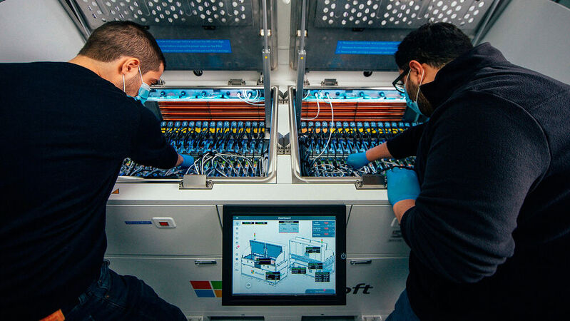 Abbildung 4: Flüssigkeitskühlung im offenen Bad: Die beiden Software-Ingenieure inspizieren das Innere eines Zweiphasen-Tauchkühltanks in einem Microsoft-Rechenzentrum. 