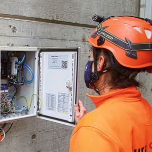 Ramona Keller, Leiterin Instandhaltung der Jura-Cement-Fabriken, beim Checken der IoT-Box, die die gesammelten Daten über die mobile Verbindung an die Premas-Cloud sendet. (Bild:  Aumund)