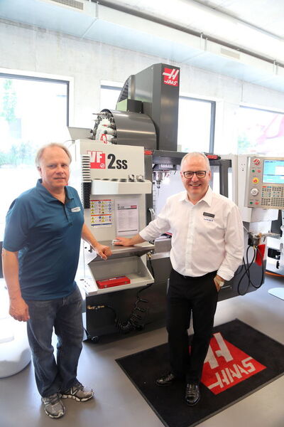 Gene Haas directeur général de Haas Automation Inc, et Urs W. Berner directeur d'Urma AG le distributeurs des machines-outils Haas en Suisse (de gauche à droite). En arrière plan le centre d'usinage Haas VF-2SS Super-Speed 762x406x508 mm, 22,4 kW et 12'000 tr/min. (JR Gonthier)