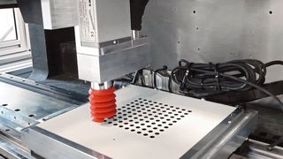 Bild 1: In nur 17 Sekunden schafft es die High Speed Drilling Unit 100 Löcher mit einem Durchmesser von 6 mm und 6 mm Tiefe präzise in eine beschichtete Verbundholzplatte zu bohren. (Yaskawa)