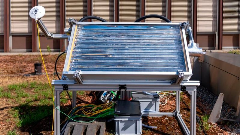 Kollektor im Test-Setup: Der Kollektor wird an einen Rahmen befestigt und an die "control und measurement" Box (unten und hinten) angeschlossen. Links oben am Rahmen wird zusätzlich ein Pyranometer befestigt, welcher die eintreffende Strahlung misst.(Bild:  Michel Büchel / ETH Zürich)