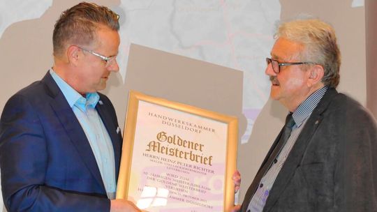 Oliver Nienhaus (l.), Obermeister der Karosseriebauerinnung Köln, übergab den goldenen Meisterbrief an Heinz-Peter Richter.  (Bild:  Kfz- und Karosseriebauer-Innung Köln)