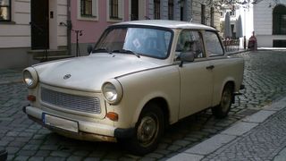 Der Trabi in undefinierbarem hellem Anstrich. Nach der Wende wurde er rasch gegen Westfahrzeuge ausgetauscht. Nur noch ein harter Kern blieb der Rennpappe treu. Heute, 60 Jahre nach seinem Messe-Debüt, werde er jedoch immer beliebter – doch nicht bei allen ... (Bild: VEB Sachsenring)