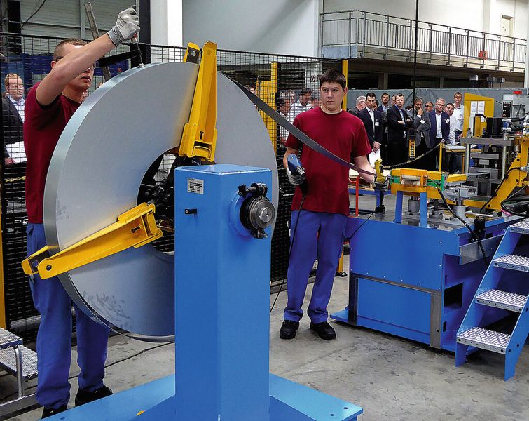 Die Gäste waren gute Beobachter, als zwei Mechaniker von Dreistern den Stanzeinheiten-Wechsel demonstrierten; zuerst musste das Band fixiert und getrennt werden. (Bild: Kuhn)