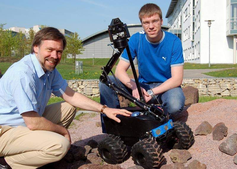 Prof. Klaus Schilling (links) und Daniel Eck mit dem preisgekrönten Roboterfahrzeug Merlin.  Bild: Robert Emmerich (Archiv: Vogel Business Media)