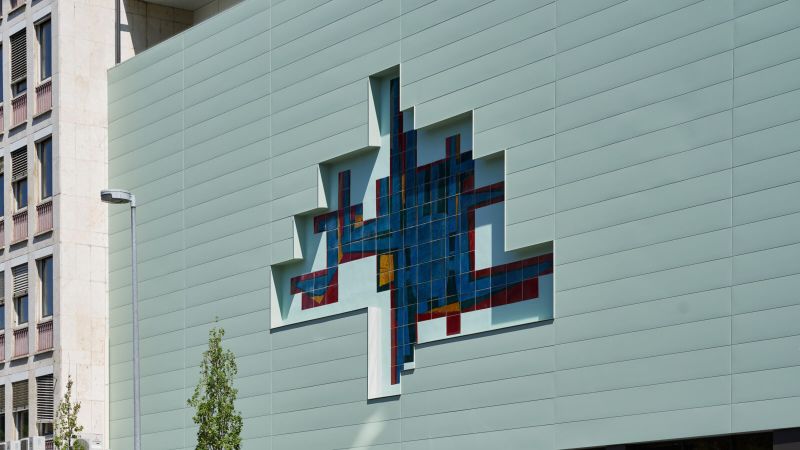 Bei der Fassadensanierung eines Gymnasiums in Koblenz rahmt die FC Fassade das kunstvolle Fliesenmosaik ein.(Bild:  Kalzip GmbH)