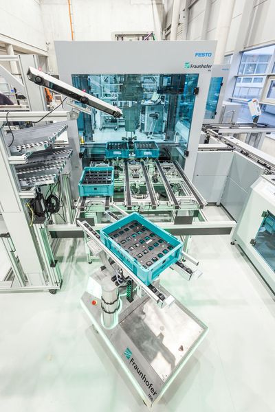 Mithilfe interner und externer Lokalisierungssensoren können sich Fahrerlose Transportsysteme (FTS) zum Beispiel bei der Übergabe von Lasten bis in den Millimeterbereich genau positionieren. (Fraunhofer-IPA/Rainer Bez)