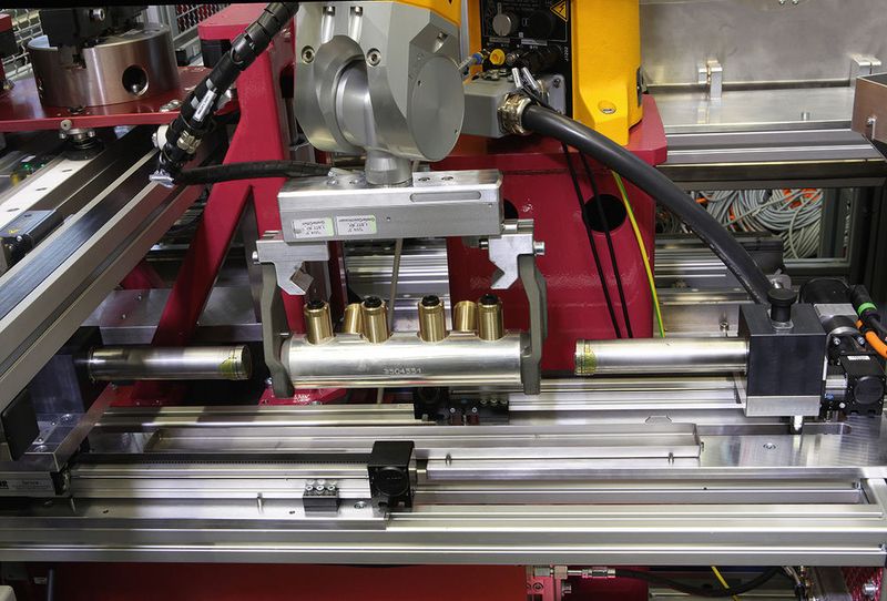 Ein Knickarmroboter hält den Grundkörper für die Befettung durch entsprechende Dorne parat. (Bild: Ralf Högel)