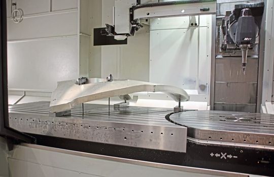 Bearbeitung eines geometrisch anspruchsvollen Werkstücks aus Aluminium. Die Gesamtbelastbarkeit beider Tische, fester Spannbereich und Drehtisch, liegt bei 13 Tonnen. Bearbeitung eines geometrisch anspruchsvollen Werkstücks aus Aluminium. Die Gesamtbelastbarkeit beider Tische, fester Spannbereich und Drehtisch, liegt bei 13 Tonnen.