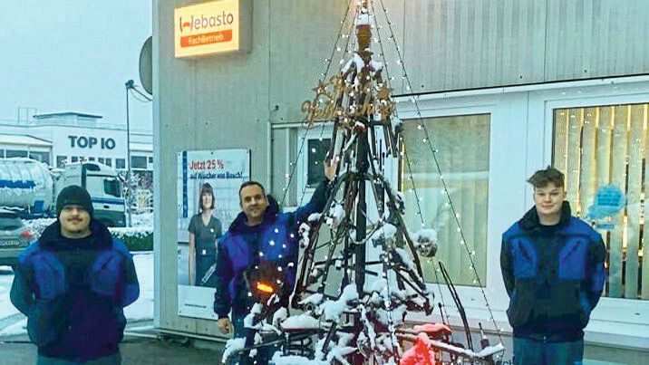 Obermeister Paulo Rodrigues (Mitte) freut sich über den kreativen Weihnachtsbaum aus alten Kfz-Teilen und ist stolz auf seine Azubis Marco Mancino (links) und Linus Walter (rechts).