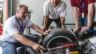 MVI-Geschäftsführer Rainer Kurek (Mitte) macht sich selber ein Bild von den Verbesserungen am Rennfahrzeug. (Foto: Kristof Vermeulen)
