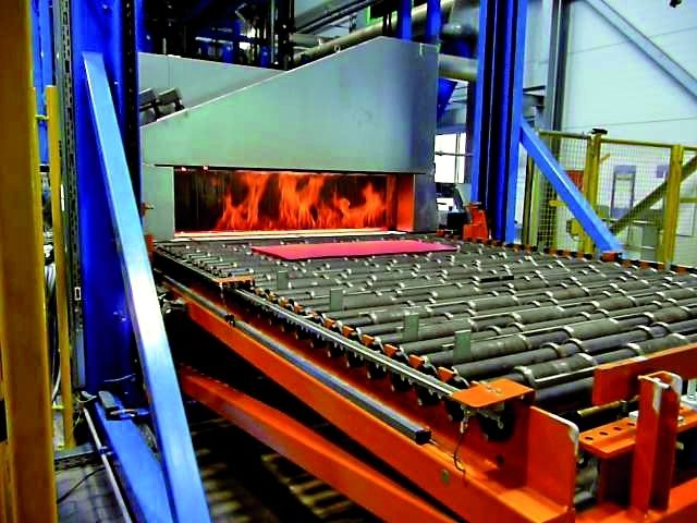 Mit etwa 940 bis 970 °C verlassen die Platinen den Rollenherdofen um anschließend von einem Roboter mit Klemmgreiferspinne in das Werkzeug gelegt zu werden. (Archiv: Vogel Business Media)