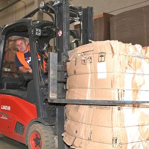 Per Gabelstapler mit spezieller Ballenklammer werden die schweren Kartonballen bis zum Abtransport vor die Halle gebracht.