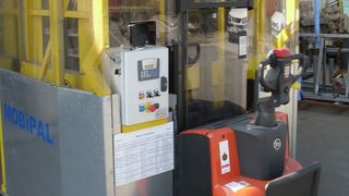 Der Bediener steht auf einem hinten am Mobipal angebrachten Podest, von dem aus er den motorisierten Staplerwagen steuern und die Paletten ganz einfach an gewünschten Stellen einsammeln beziehungsweise verteilen kann. (Bild: Triax Sicherheitstechnik)