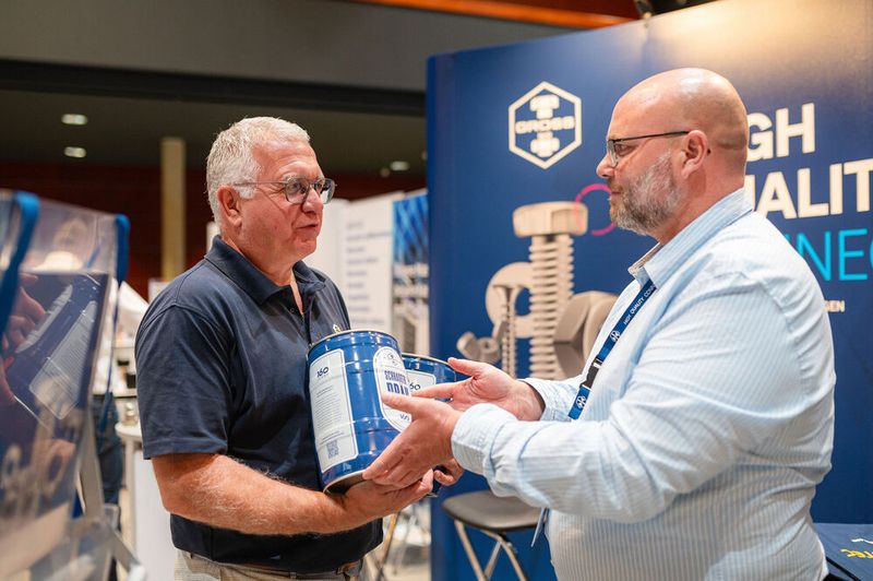 Passender Durstlöscher: Sven Zimmermann (rechts) vom Schraubenspezialisten Ferdinand Gross übergibt Bernd Weinig, Director Trade Fair Solutions & Partnerships bei der Vogel Communications Group ein Fass Schrauben Bräu.  (Bild: Donna und der Blitz)