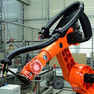 Die Triflex-Energiekette ist mehrdimensional beweglich und kann so platzsparend parallel zum Roboterarm geführt werden Bild: Igus