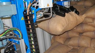 Das System von Copal greift die Kaffeesäcke automatisch und befördert sie über ein Förderband weiter. (Copal)