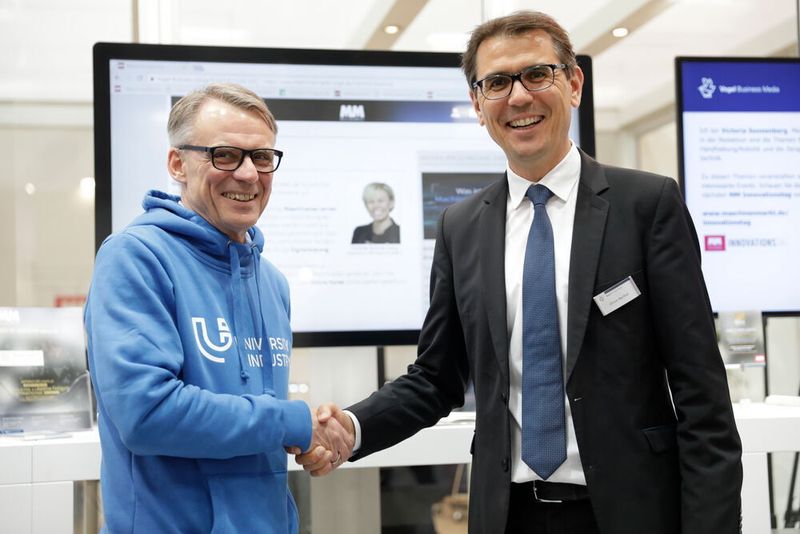 Dr. Wolfgang Huhn (Geschäftsführer University4Industry) und Oliver Barthel (Group Publisher MM MaschinenMarkt) besiegeln die neue Kooperation zwischen MM Maschinenmarkt und U4I. (Michael Heck Fotografie)