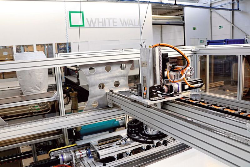 Das Portal-Drehkreuz entnimmt die Leiste aus der Schwenkkulisse und platziert sie auf dem Bildträger.  (Bild: SEW)